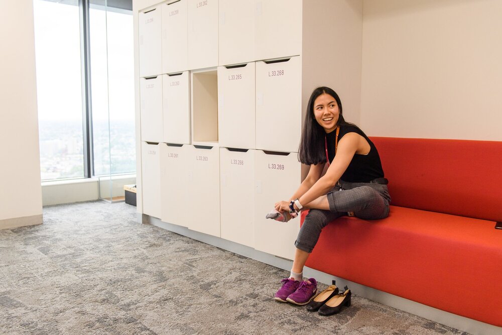 A young professional changing her shoes at the office lobby