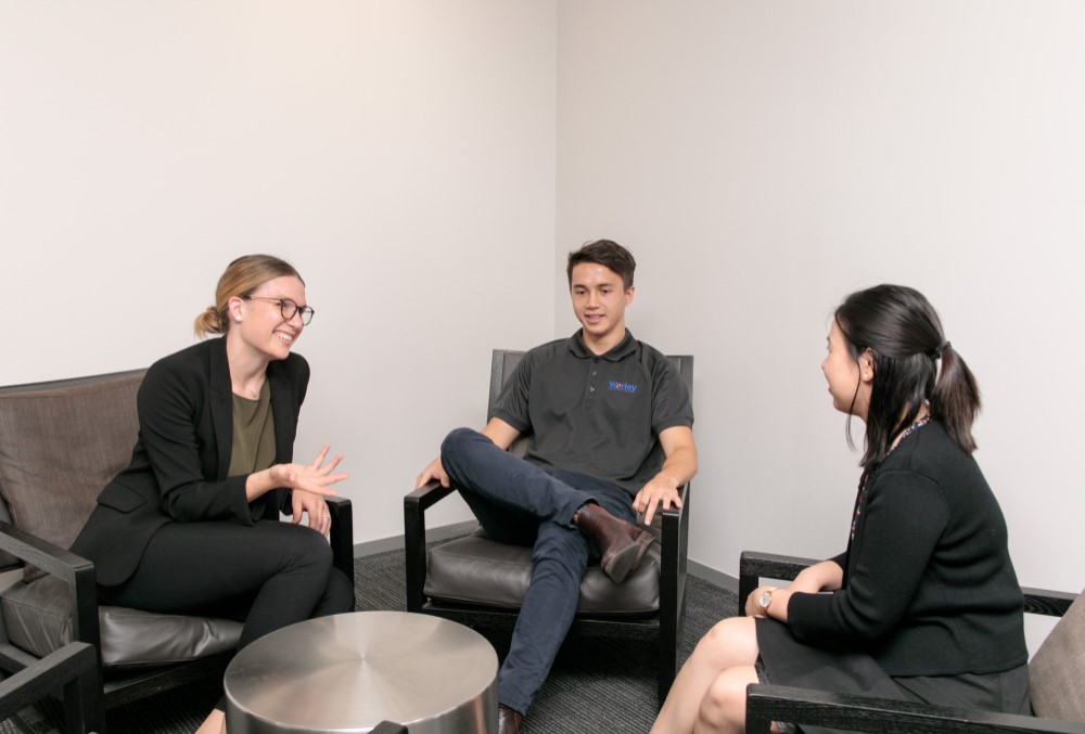 Worley Graduate - Young female professional conversing with her colleagues.