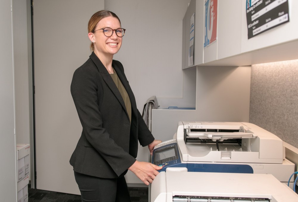 Worley Graduate - Young female professional using a photocopier.