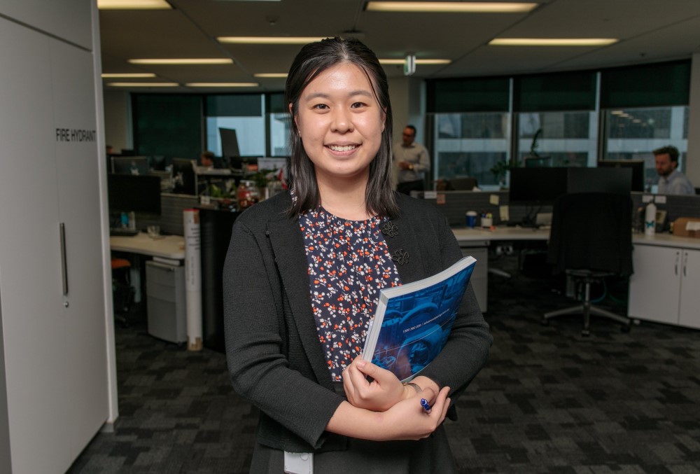 Worley Graduate - Young female professional holding a book.
