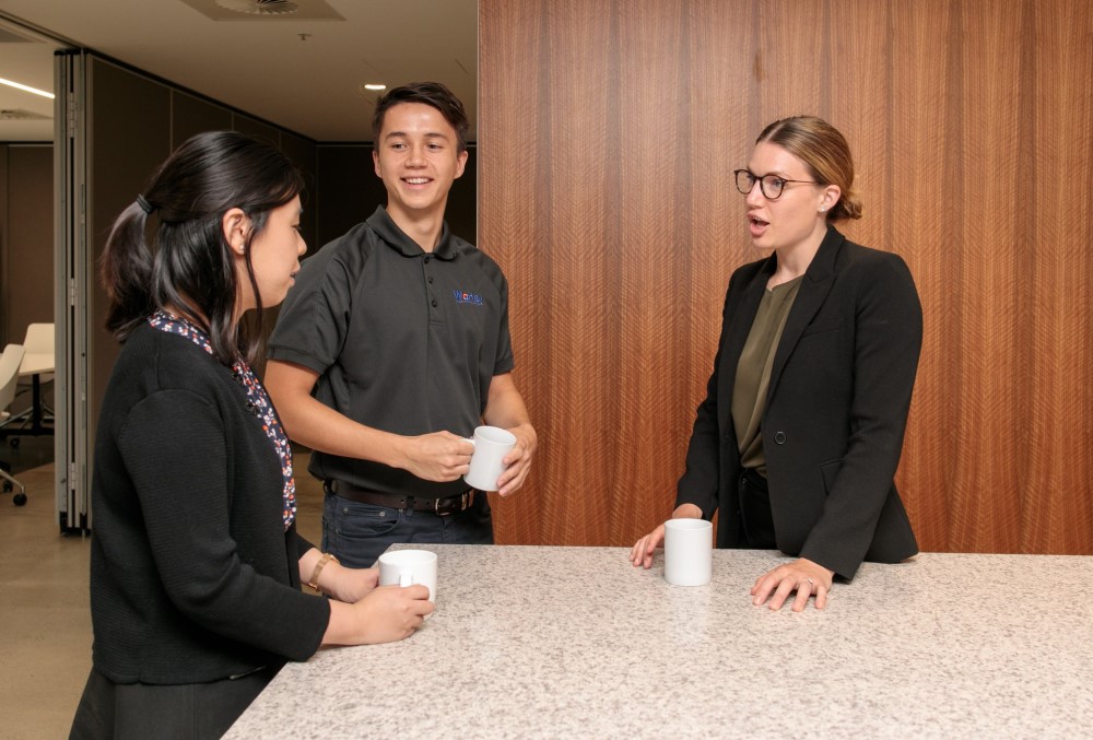 Worley Graduate - Young male professional grabbing coffee with colleagues.