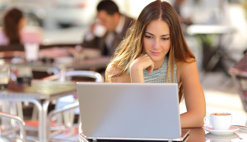 Woman sitting at a table using a laptop computer