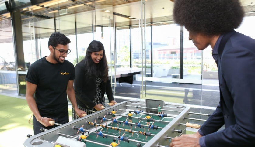 Commonwealth Bank graduates playing table soccer.